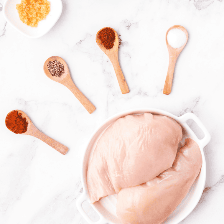 Ingredients for Jack Daniel's chicken laid out: chicken breasts, whiskey, brown sugar, pineapple juice, soy sauce, and garlic