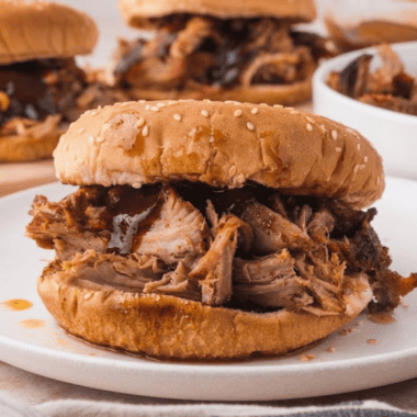 Jack Daniel's crock pot pulled pork piled on a toasted brioche bun with coleslaw and pickles