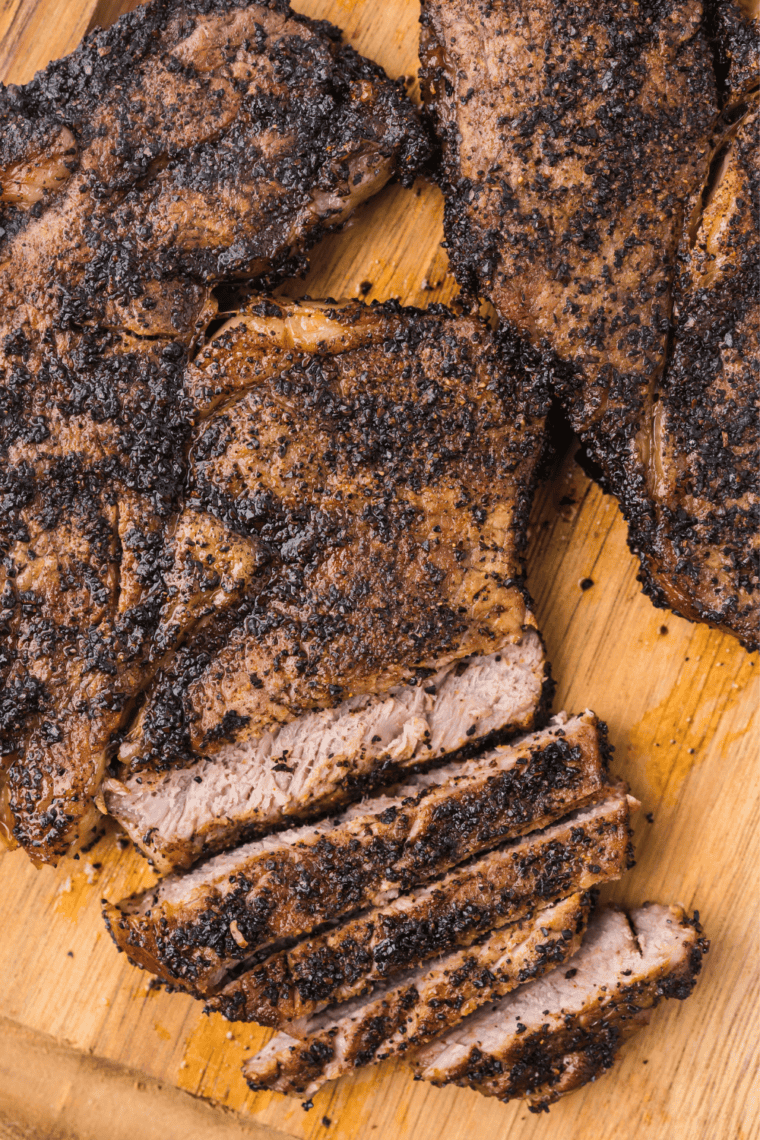 Sliced Jack Daniel's rib eye steak showing a juicy medium-rare pink center, drizzled with whiskey glaze