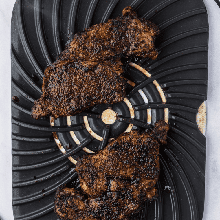 Jack Daniel's rib eye steak searing in a hot cast iron skillet with a brown crust