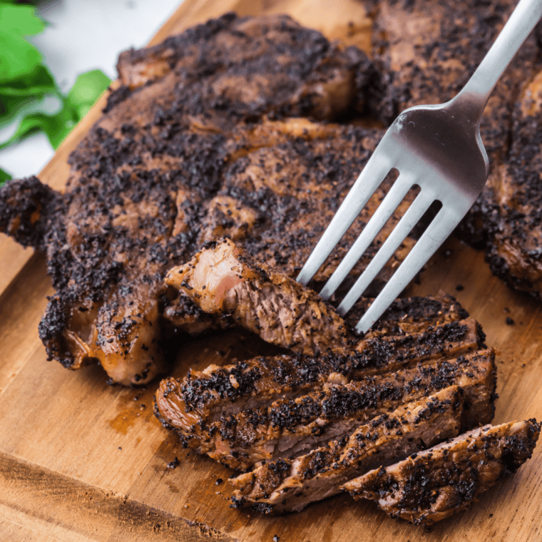 Jack Daniel's rib eye steak sliced and drizzled with whiskey glaze on a plate