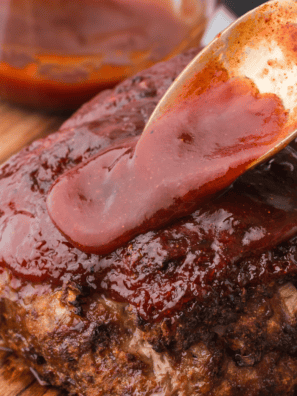 Jack Daniels meatloaf sliced on a wooden board, glazed with sticky whiskey BBQ sauce