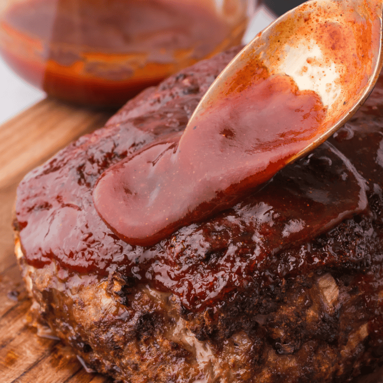 Jack Daniels meatloaf sliced on a wooden board, glazed with sticky whiskey BBQ sauce