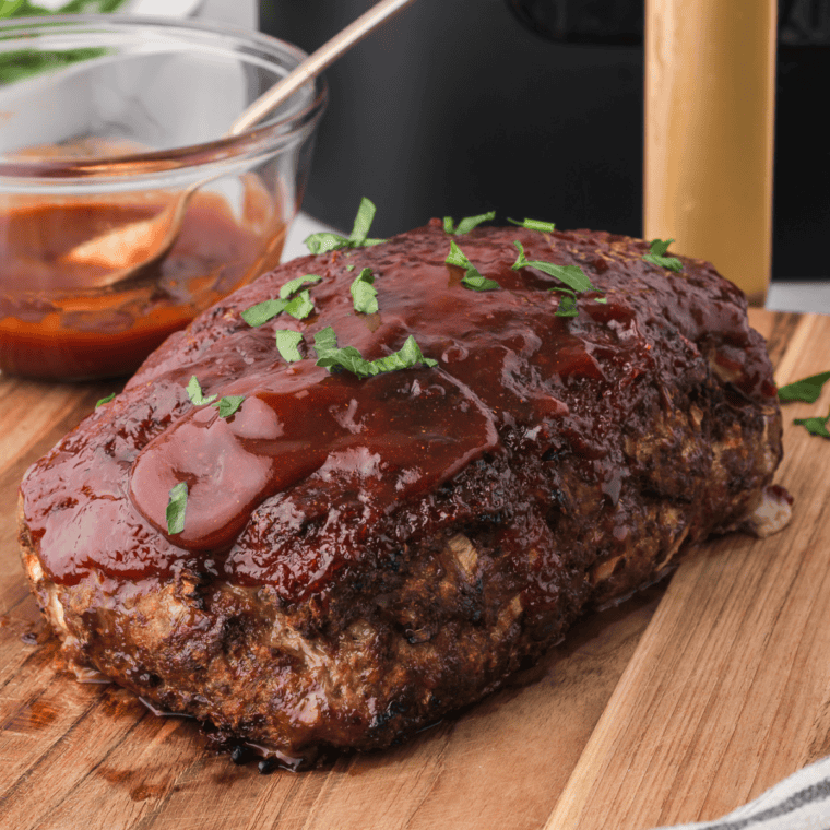 Brushing sticky Jack Daniels whiskey BBQ glaze over the baking meatloaf