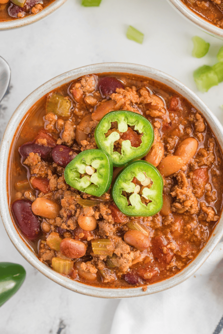 mccormick chili crockpot recipe being stirred with wooden spoon