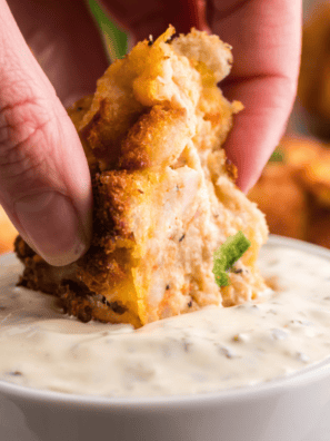 Golden fried hush puppy being dipped into creamy McCormick Mayonesa con lim&oacute;n