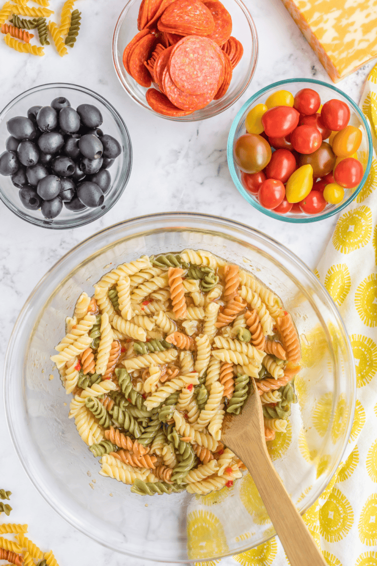 mccormick salad supreme recipe pasta salad in serving bowl with cucumbers and cherry tomatoes