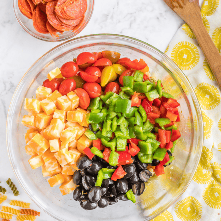 chopped cucumbers, cherry tomatoes, bell pepper, and red onion for salad supreme pasta salad