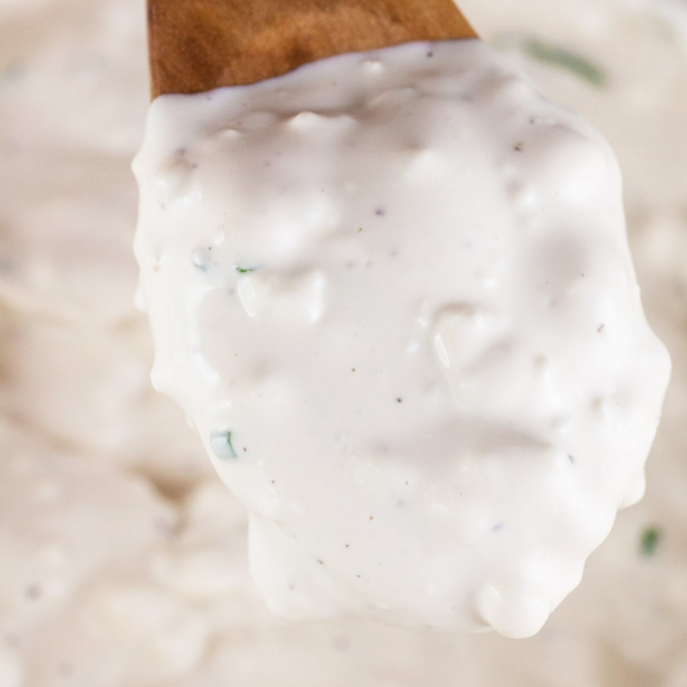 Mayonnaise, sour cream, and buttermilk whisked together in a mixing bowl until smooth and creamy.