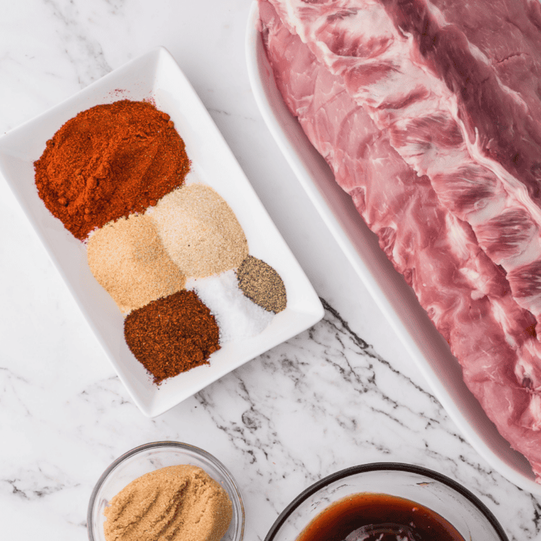 Ingredients for copycat Meat Church Honey Hog BBQ rub &mdash; sugar, brown sugar, honey powder, paprika, garlic powder, celery salt, and kosher salt in small bowls
