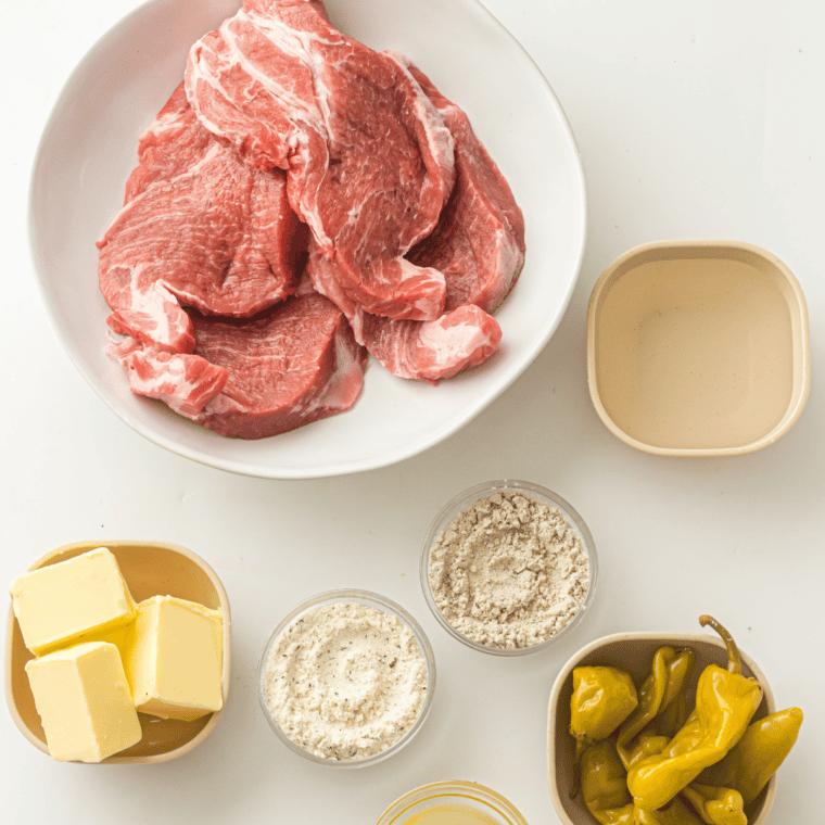 Ingredients for Slow Cooker Mississippi Pork Roast: pork shoulder, ranch mix, au jus mix, butter, and pepperoncini
