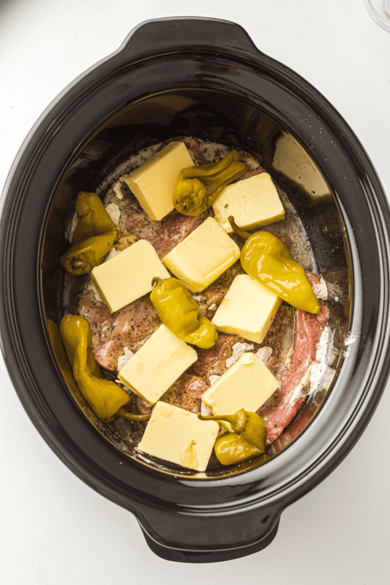 Butter and peppers:
Slow cooker pork roast topped with butter chunks and pepperoncini peppers before cooking