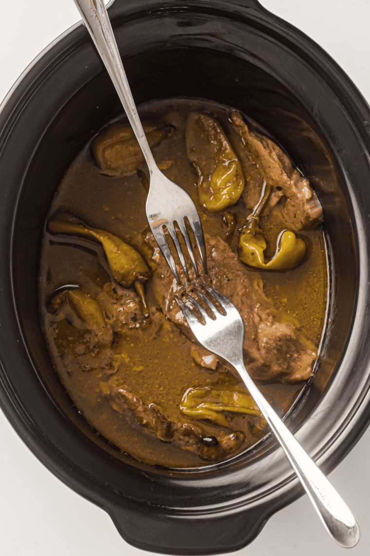 Shredded Slow Cooker Mississippi Pork Roast tossed in buttery au jus and pepperoncini.