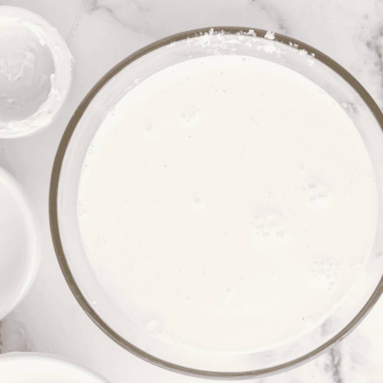 Whisking sugar, cream cheese, salt, and milk in a mixing bowl until smooth