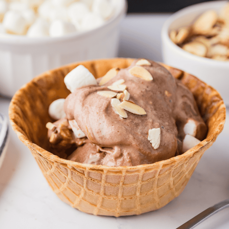 Bowl of homemade Blue Bell Rocky Road copycat ice cream made in the Ninja Creami, garnished with marshmallows and almonds