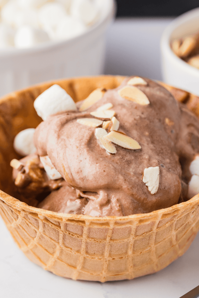 Creamy dark chocolate Ninja Creami Rocky Road ice cream served in a white bowl with a spoon
