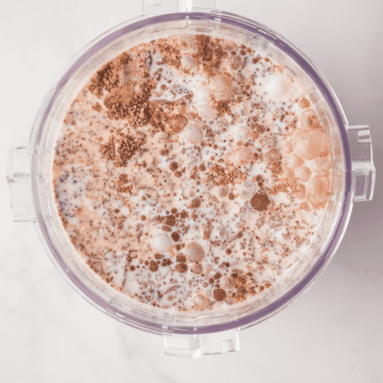 Whisking milk, cream, sugar, Dutch cocoa, and pudding mix in a bowl into a smooth Ninja Creami Rocky Road base