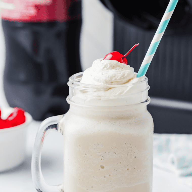 Ninja Creami Jack in the Box Pumpkin Pie Shake topped with whipped cream and a dusting of cinnamon in a tall glass