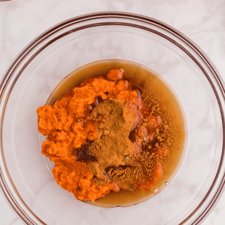 Pumpkin pie shake base being whisked smooth in a bowl with milk, cream, and spices