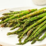 Ninja Crispi asparagus spears cooked crispy and golden in an air fryer basket