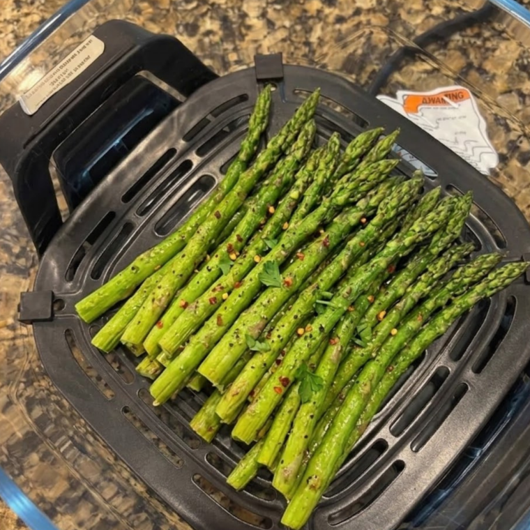 Asparagus air frying in the Ninja Crispi on the Air Fry setting under the PowerPod lid