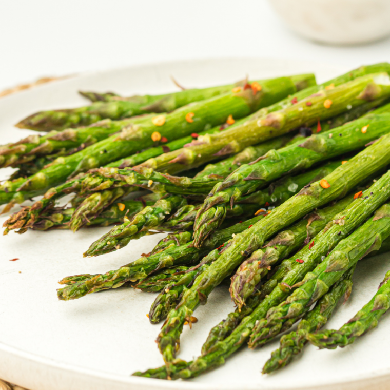 Crispy air fryer asparagus in Ninja Crispi basket topped with Parmesan cheese and lemon zest, served hot and golden