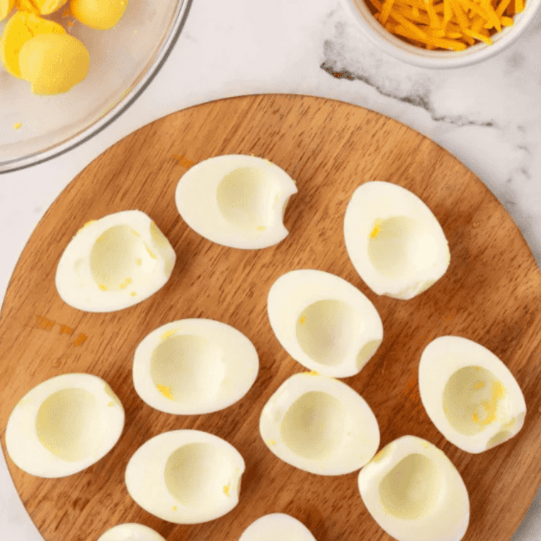 Smoked eggs sliced in half with yolks separated into a bowl