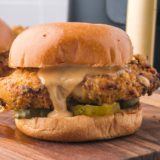 Homemade Chicken Big Mac copycat stacked tall with special sauce dripping down a sesame seed bun