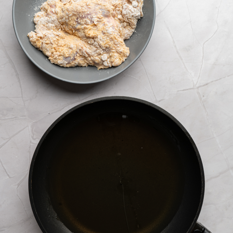 Breaded chicken patties frying in oil until deep golden brown and crispy.