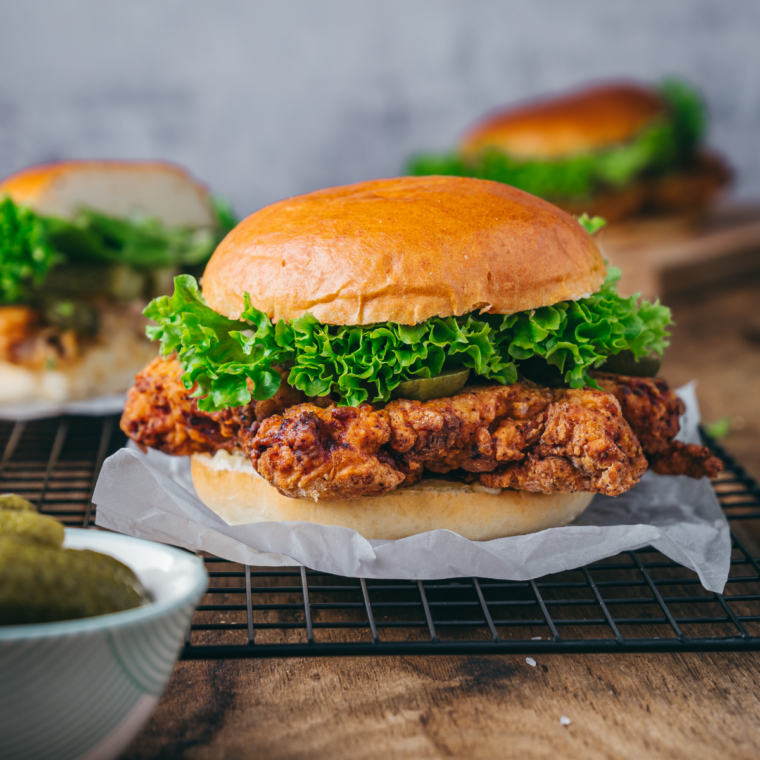 Assembling the Chicken Big Mac copycat with two crispy patties, special sauce, lettuce, and pickles