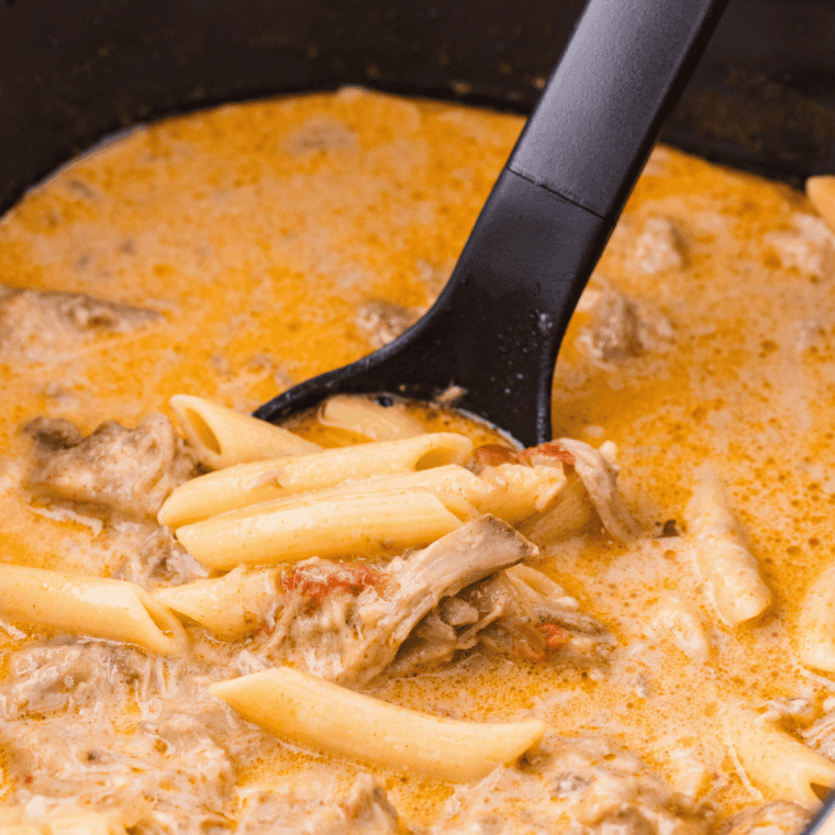 Crockpot pulled pork shredded and piled high in a white slow cooker
