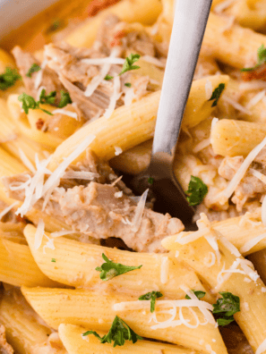 Crockpot pulled pork shredded and piled in a white slow cooker