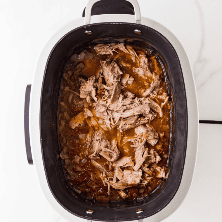 Crockpot pulled pork shredded with two forks and mixed with barbecue sauce