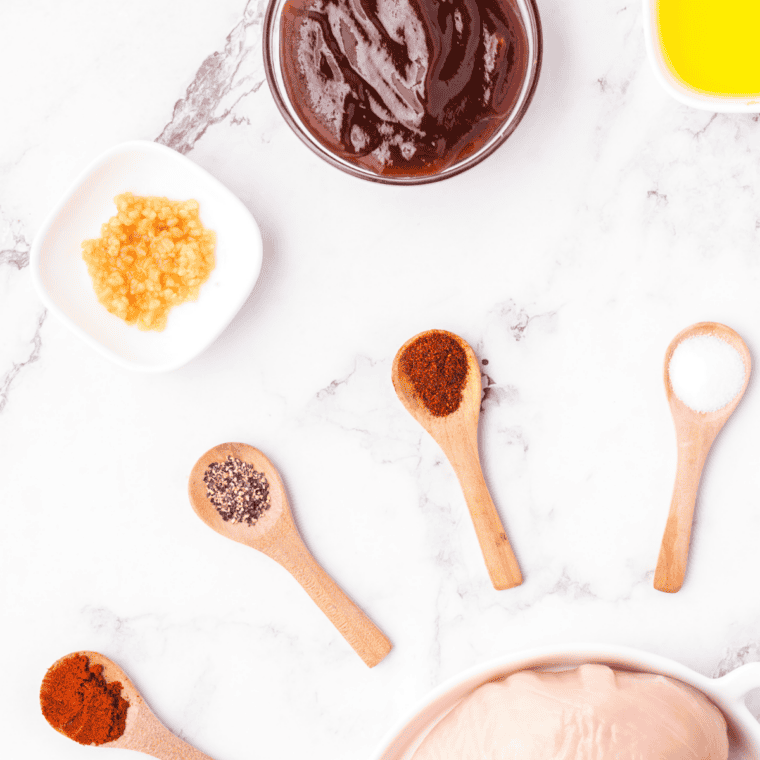 Ingredients for copycat honey bourbon marinade including honey, bourbon, ketchup, brown sugar, garlic and chipotle
