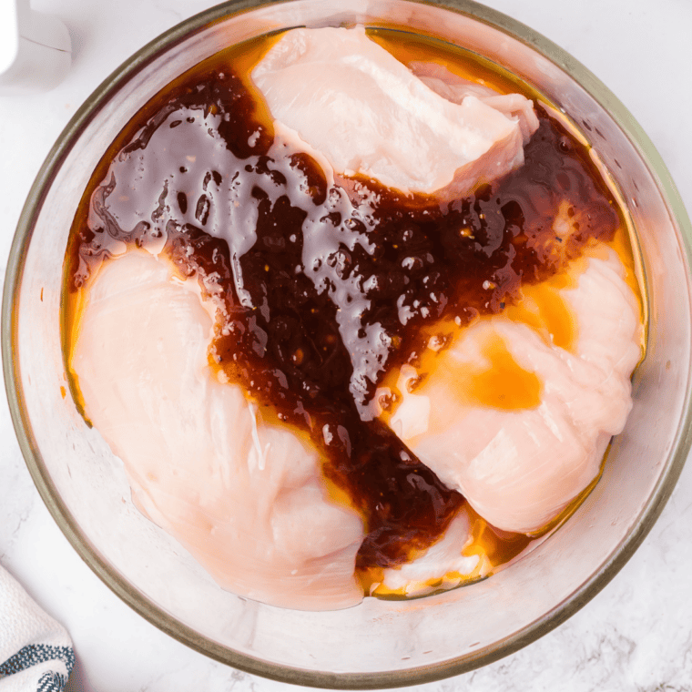 Chicken thighs marinating in copycat Lawry's honey bourbon marinade in a resealable bag