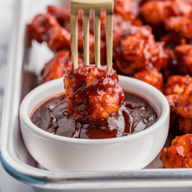 Jack Daniel's sauce in a glass jar with a spoon drizzling the glaze
