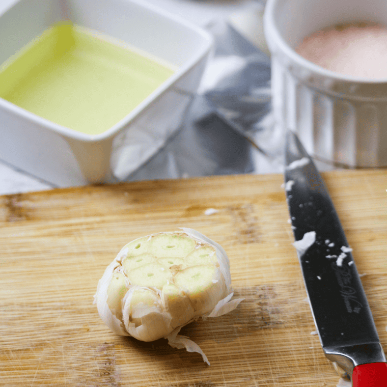 Head of garlic drizzled with olive oil and wrapped in foil for roasting