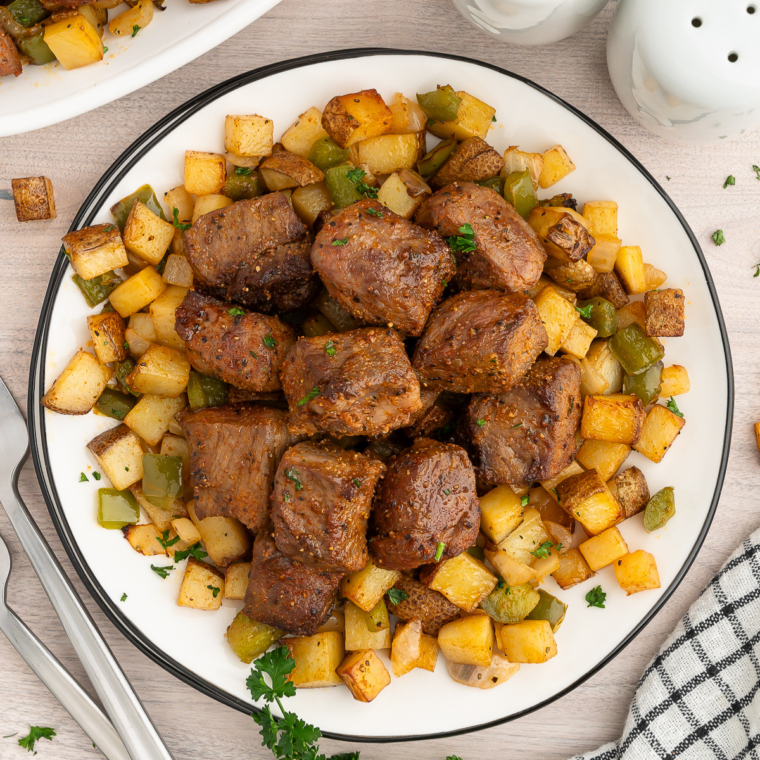 Air fryer steak bites and potatoes with crispy golden potato cubes and seared sirloin garnished with fresh parsley