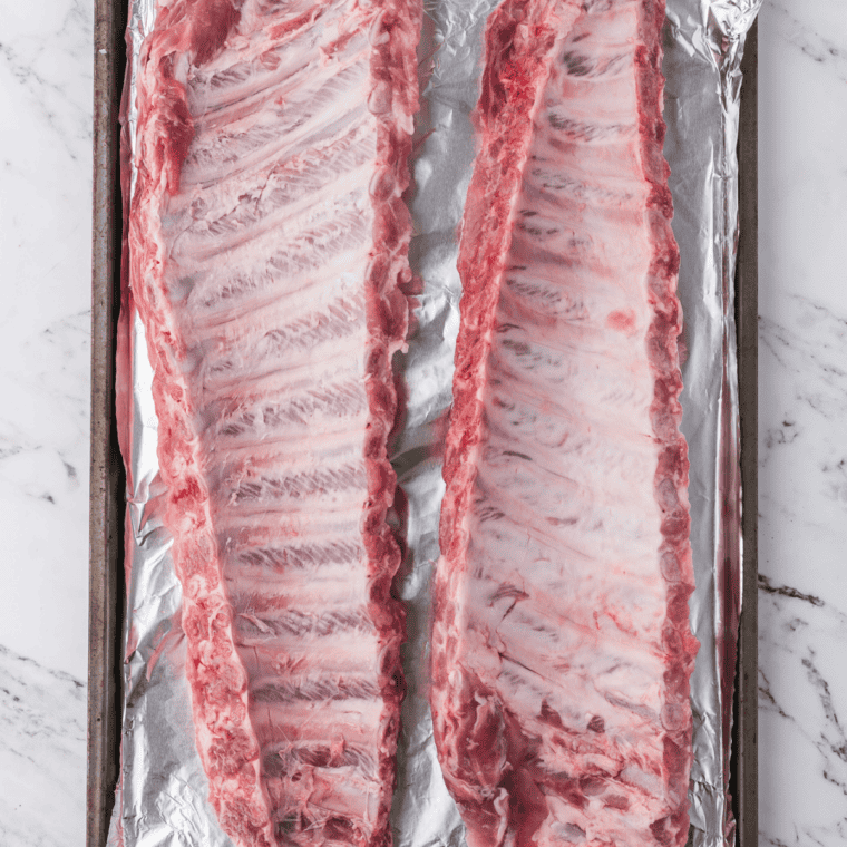 Baking sheet lined with foil for baby back ribs in the oven