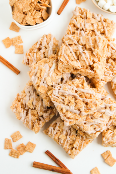Cinnamon Toast Crunch Rice Krispie Treats sliced into bars with cinnamon white chocolate drizzle