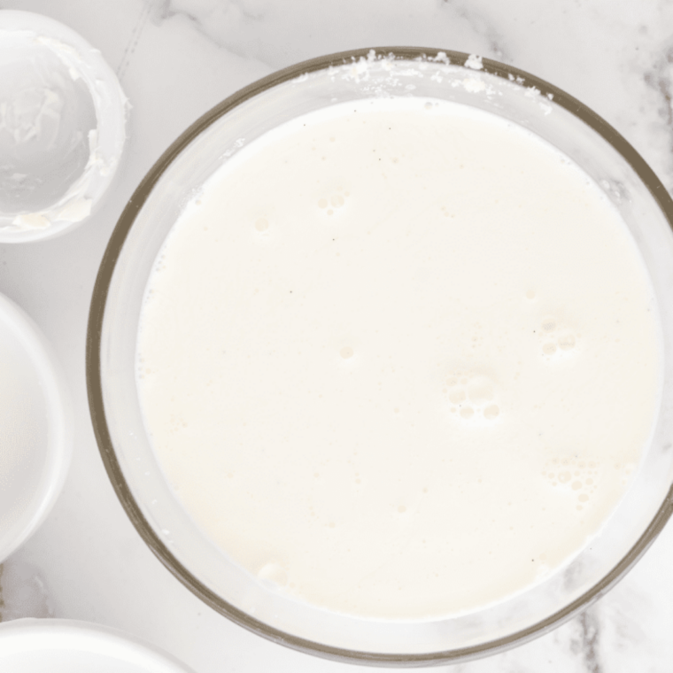 Yellow cake mix spread on a plate being heat-treated in the microwave for Ninja Creami cake batter ice cream