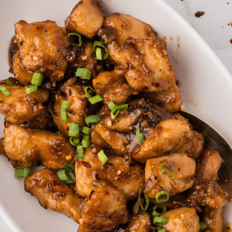 Grilled chicken on a plate drizzled with copycat Lawry's hickory brown sugar marinade sauce