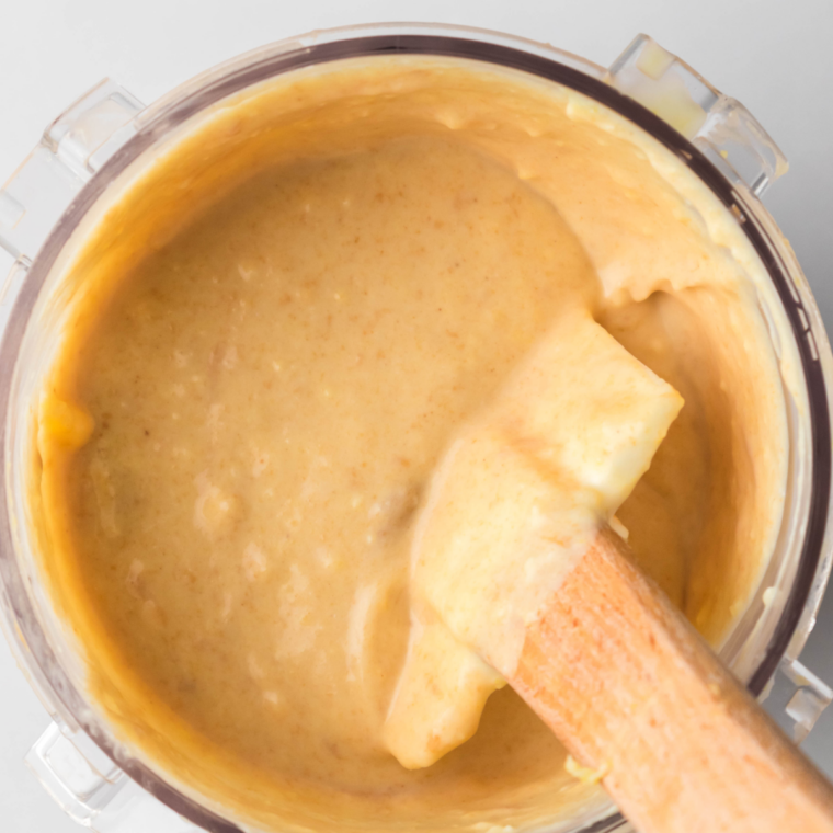 Smooth peanut butter ice cream base filled to the max line in a Ninja Creami pint before freezing.