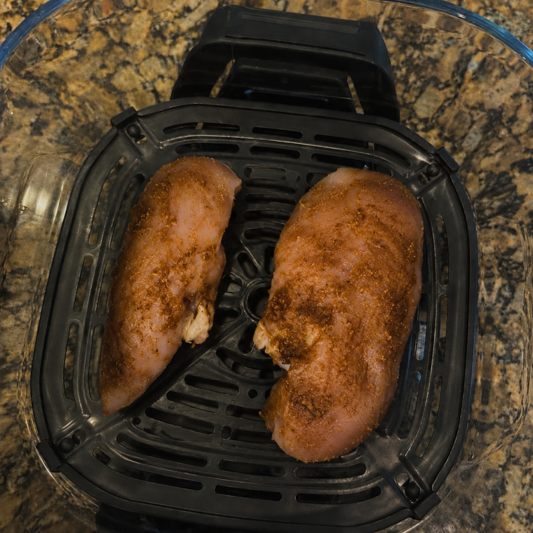 Seasoned turkey breast placed skin side up on the Ninja Crispi crisper plate