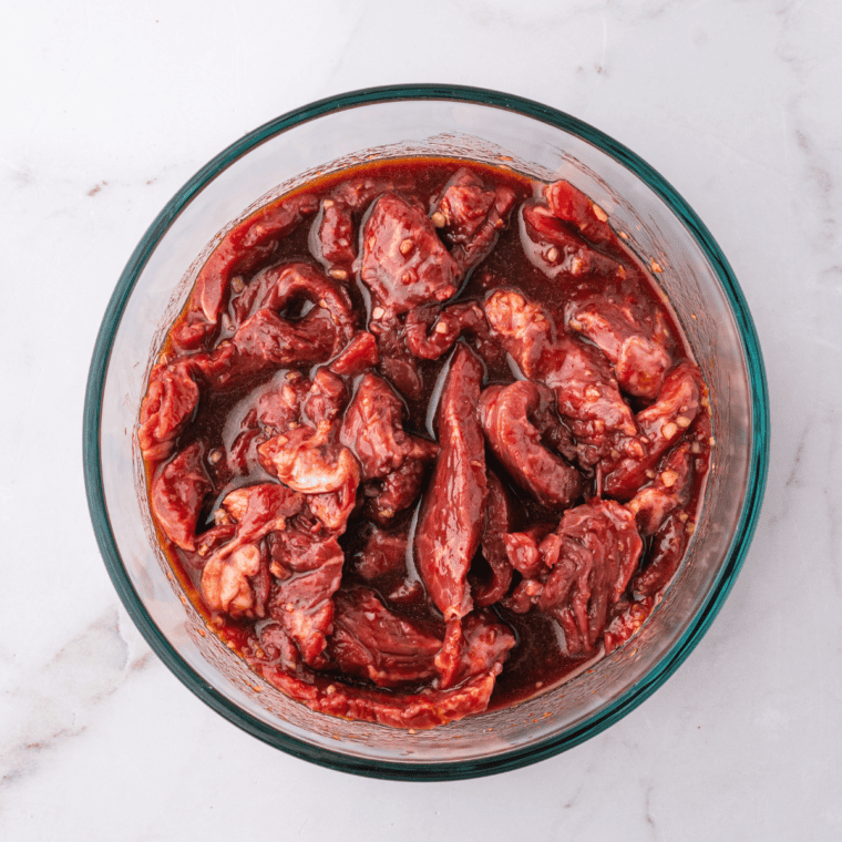 Thinly sliced beef tossed in dark bulgogi marinade in a mixing bowl
