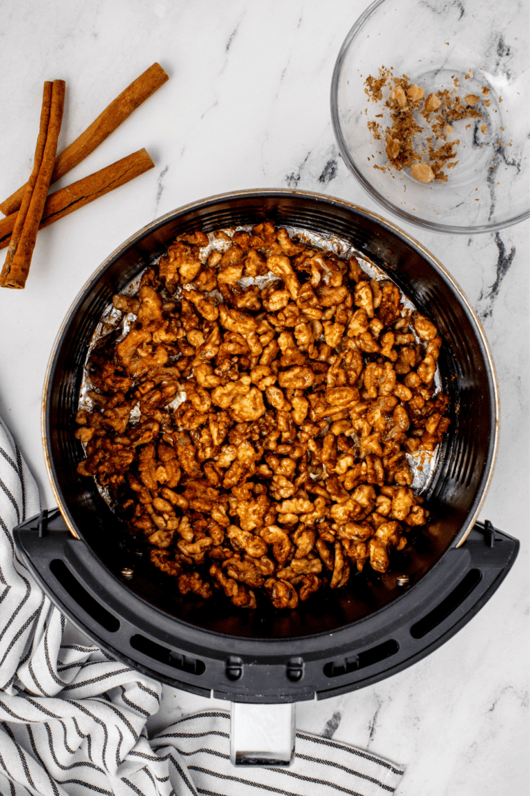 Candied coffee walnuts cooling in a single layer on a parchment-lined tray