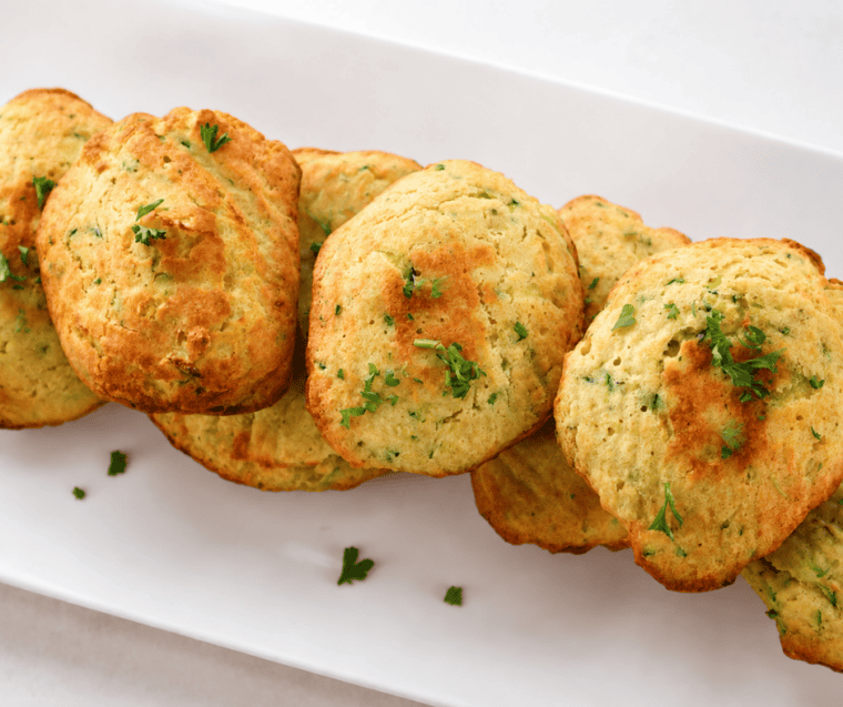 Platter of air fryer zucchini squares served with a bowl of marinara for dipping