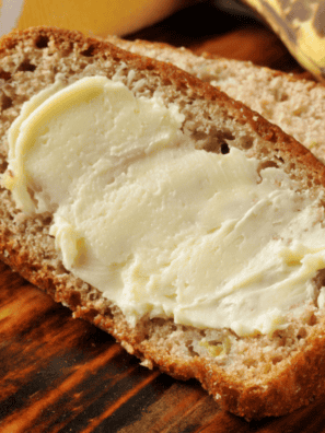 banana bread recipe Bob Evans style sliced on a wooden board showing walnuts throughout