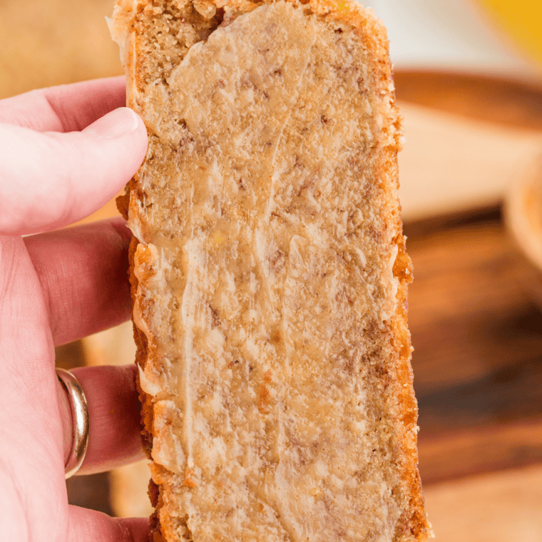 Thick slice of banana nut bread with softened butter melting into it