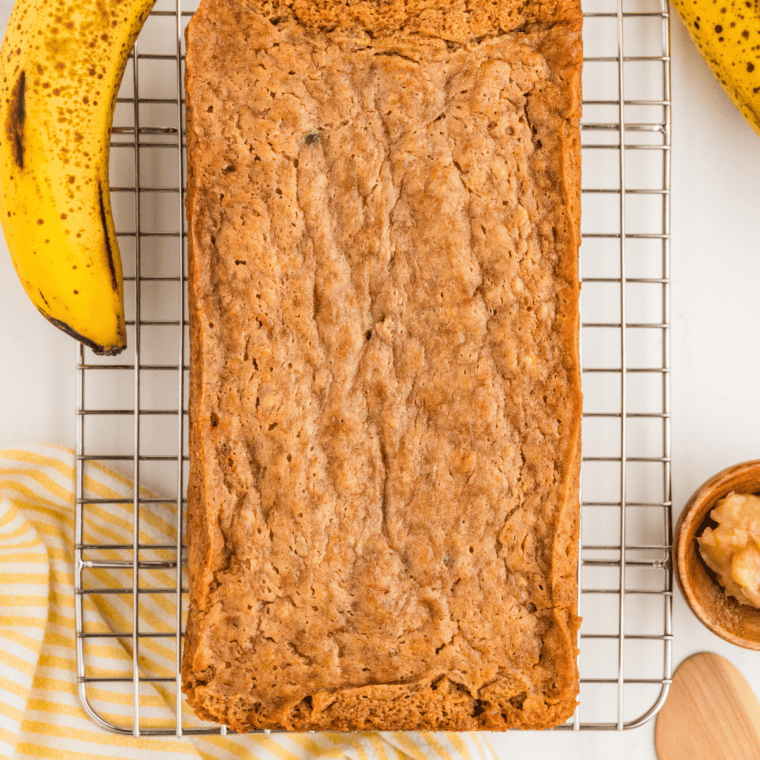 Baked copycat Bob Evans banana bread cooling on a wire rack with a cracked top